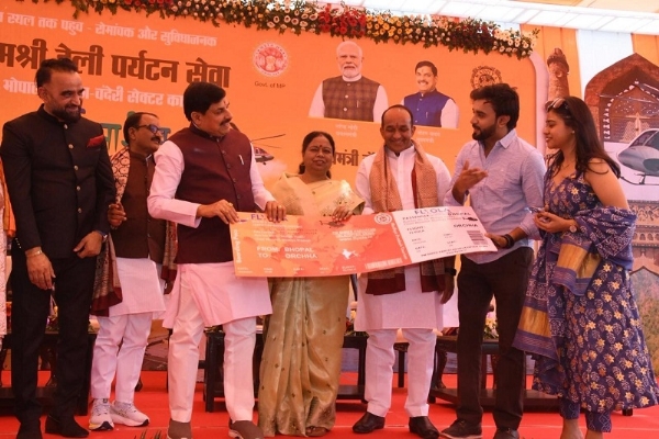 भोपाल-चंदेरी-ओरछा हेलीकॉप्टर यात्रा के शुभारंभ अवसर यात्रियों को बोर्डिंग पास देते हुए मुख्यमंत्री
