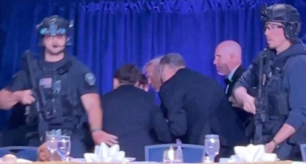 वाशिंगटन में व्हाइट हाउस कॉरेस्पोंडेंट्स डिनर के दौरान कार्यक्रम स्थल के बाहर हुई गोलीबारी में सीक्रेट सर्विस के एजेंट राष्ट्रपति डोनाल्ड ट्रंप को सुरक्षित स्थान पर ले जाते हुए।  फोटो - इंटरनेट मीडिया