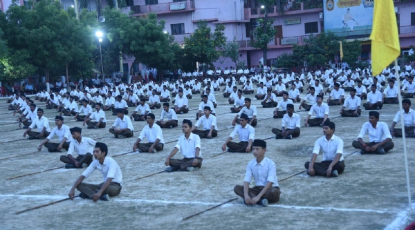 मैदान में बैठे स्वयंसेवक