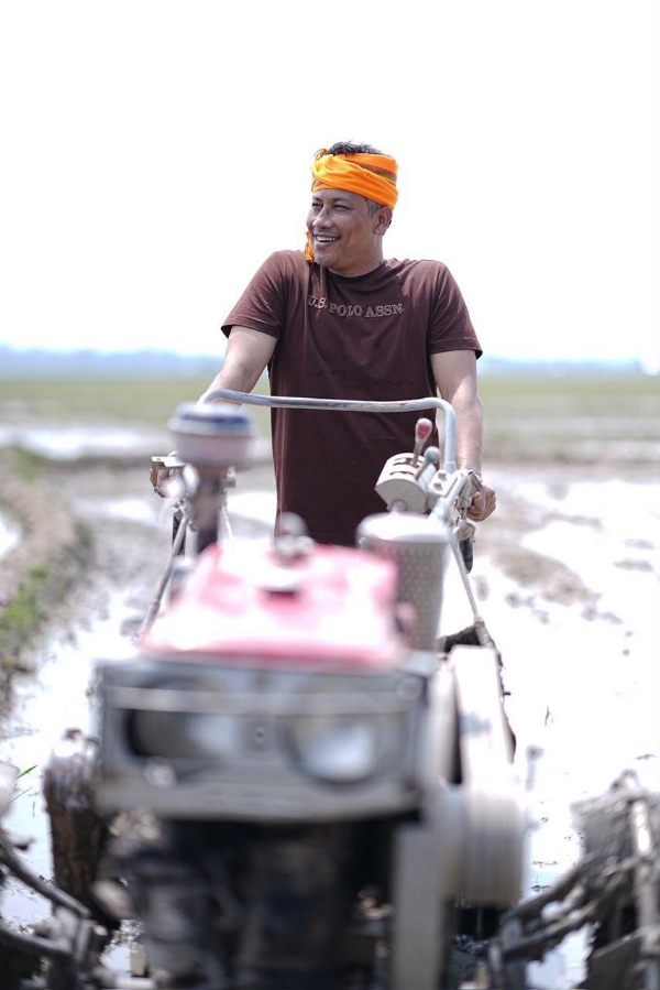 হাতত কঠিয়া লৈ শাওনৰ পথাৰত ভূঁই ৰোৱাত ব্যস্ত কৃষি মন্ত্ৰী পীযুষ হাজৰিকা
