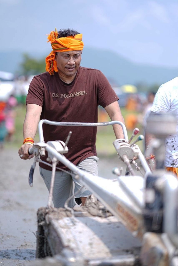 হাতত কঠিয়া লৈ শাওনৰ পথাৰত ভূঁই ৰোৱাত ব্যস্ত কৃষি মন্ত্ৰী পীযুষ হাজৰিকা