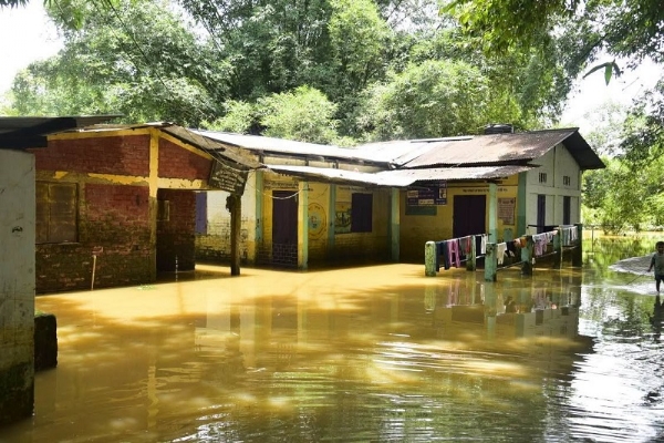 असम बाढ़ः बाढ़ के पानी में डूबा प्राथमिक विद्यालय का दृश्य